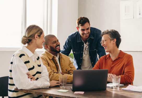 Case Study - Agilyx - Image Image of two men and two woman at a table working on a laptop