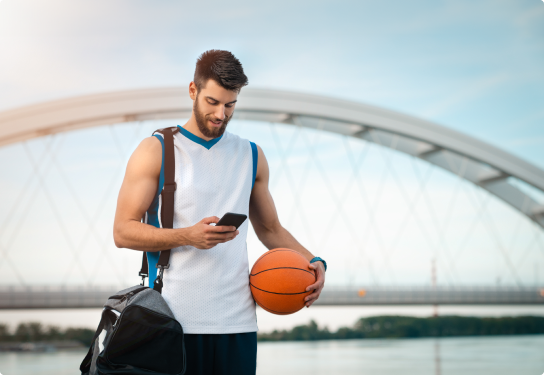 Case Study - Breakers - Image Image of a man texting on a mobile phone while holding a basketball in sports gear