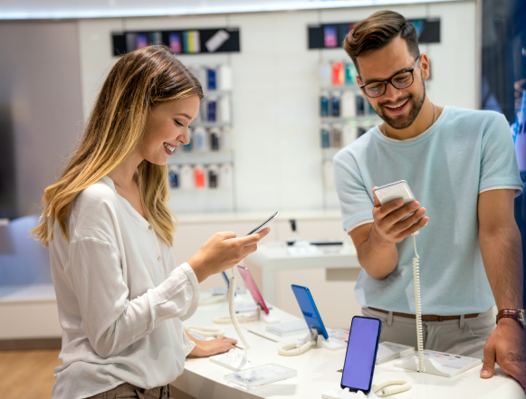 Trade In - In store - Image Man and a woman looking at mobile phones in a store