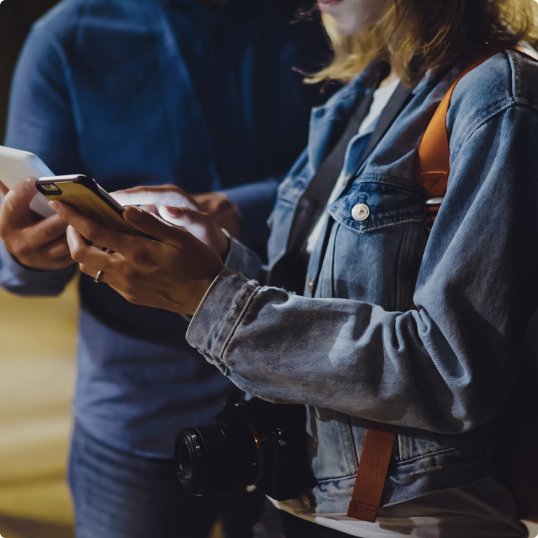 Image of a woman in a denim jacket showing man her phone