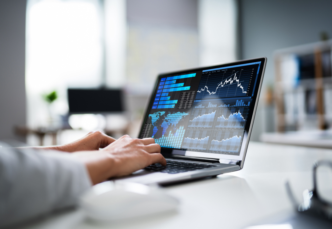 Image of a laptop with graphs and maps on the screen