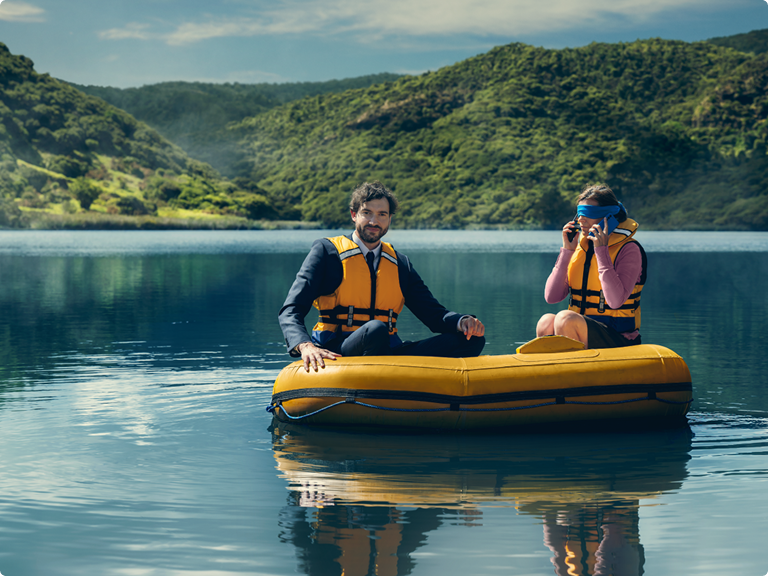 two people sitting in an inflatable dingy on a lake